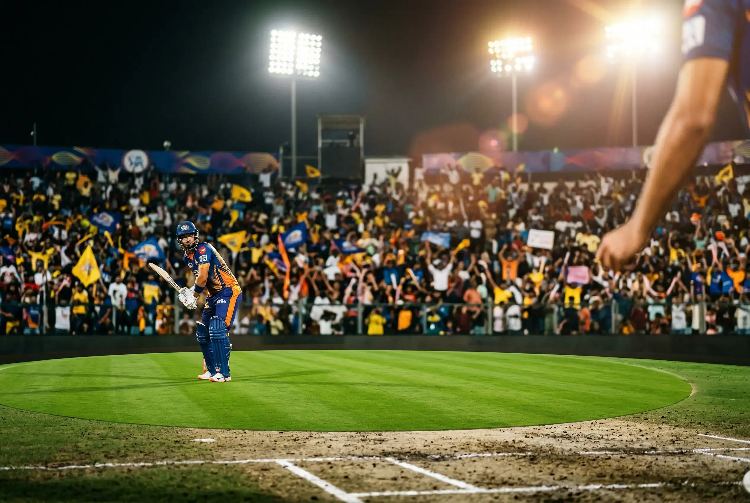 Estadio de cricket durante un partido de la IPL con graficos de cuotas de apuestas superpuestos